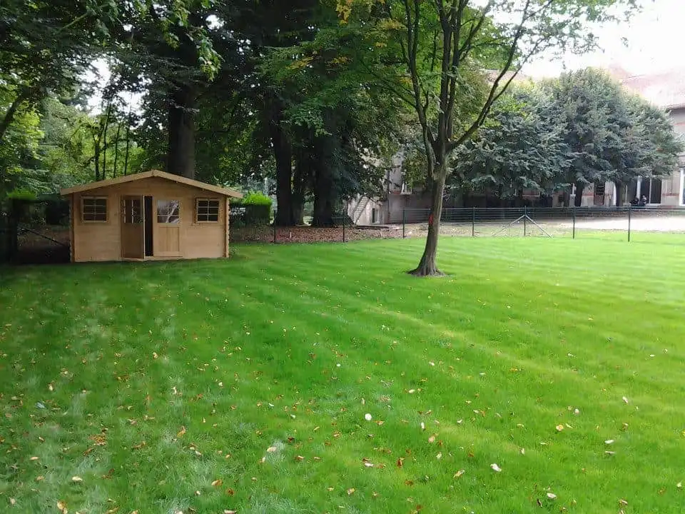 Grande pelouse entretenue avec abri de jardin en bois